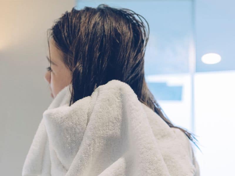 woman towel drying her wet hair