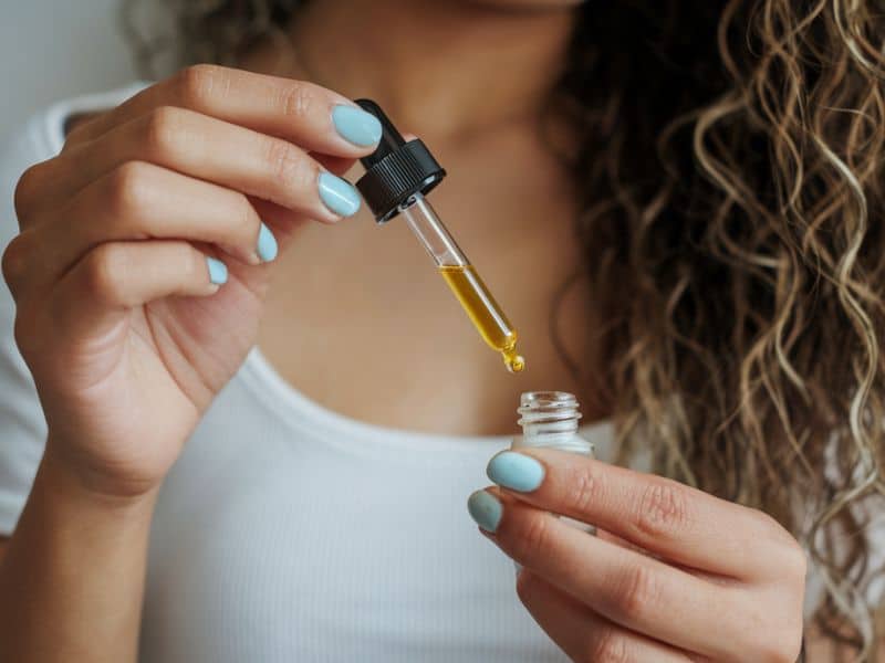 woman applying hair oil