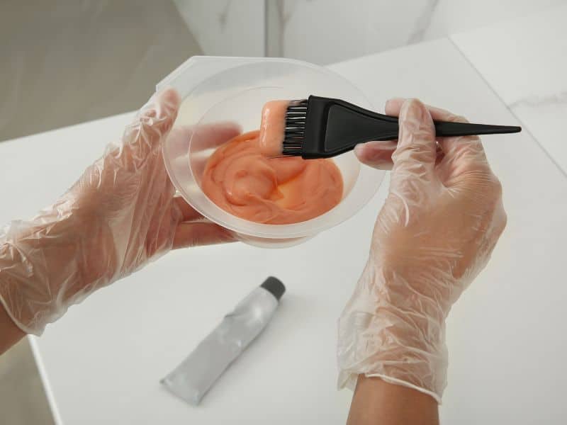 image of a person mixing hair dye formula in a bowl