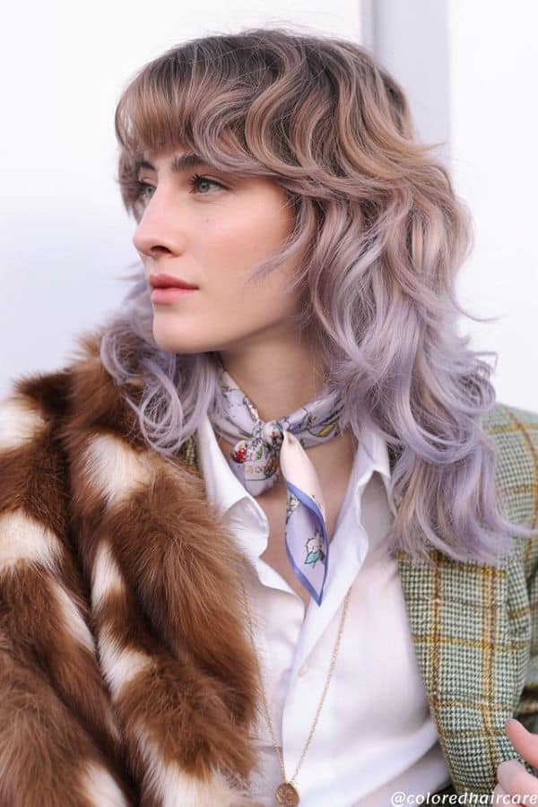 Creative studio shot of a heavily layered, mullet-inspired shag haircut (wolf cut style) with pastel lavender dip-dyed tips, light brown base, choppy ends, windblown texture, playful and modern TikTok aesthetic